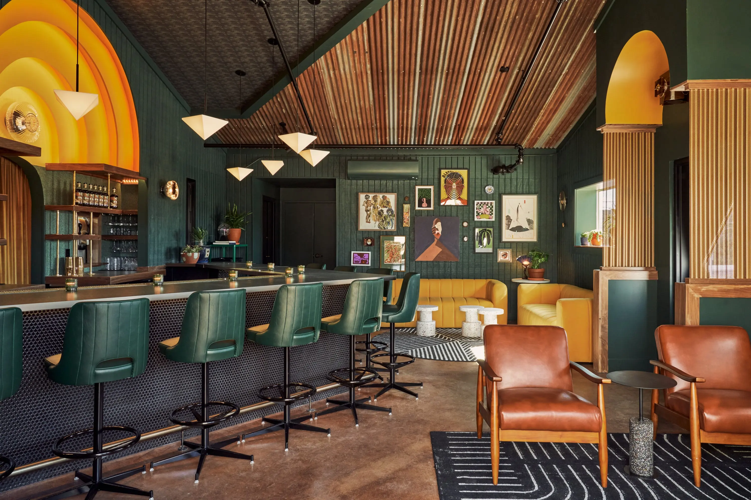 Senza Maeso tasting room bar with arched amber back bar, green leather stools and a timber ceiling