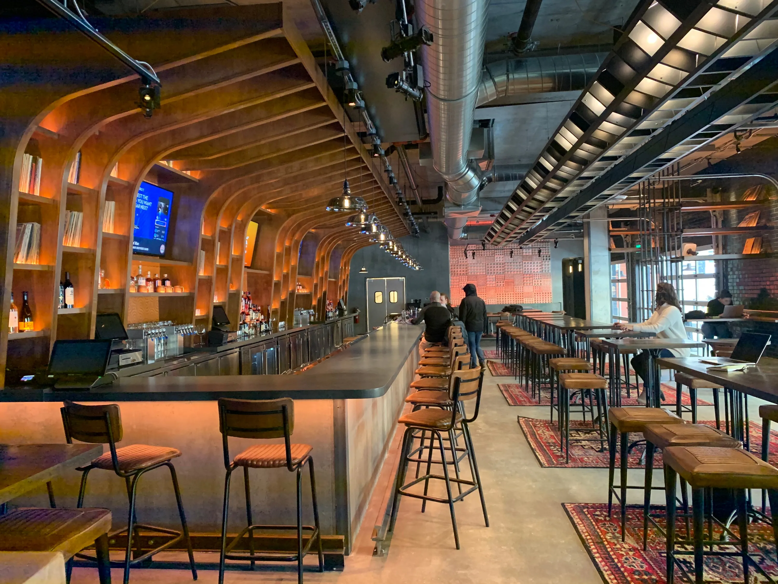 Trax bar with a long wall of illuminated record casework and stools