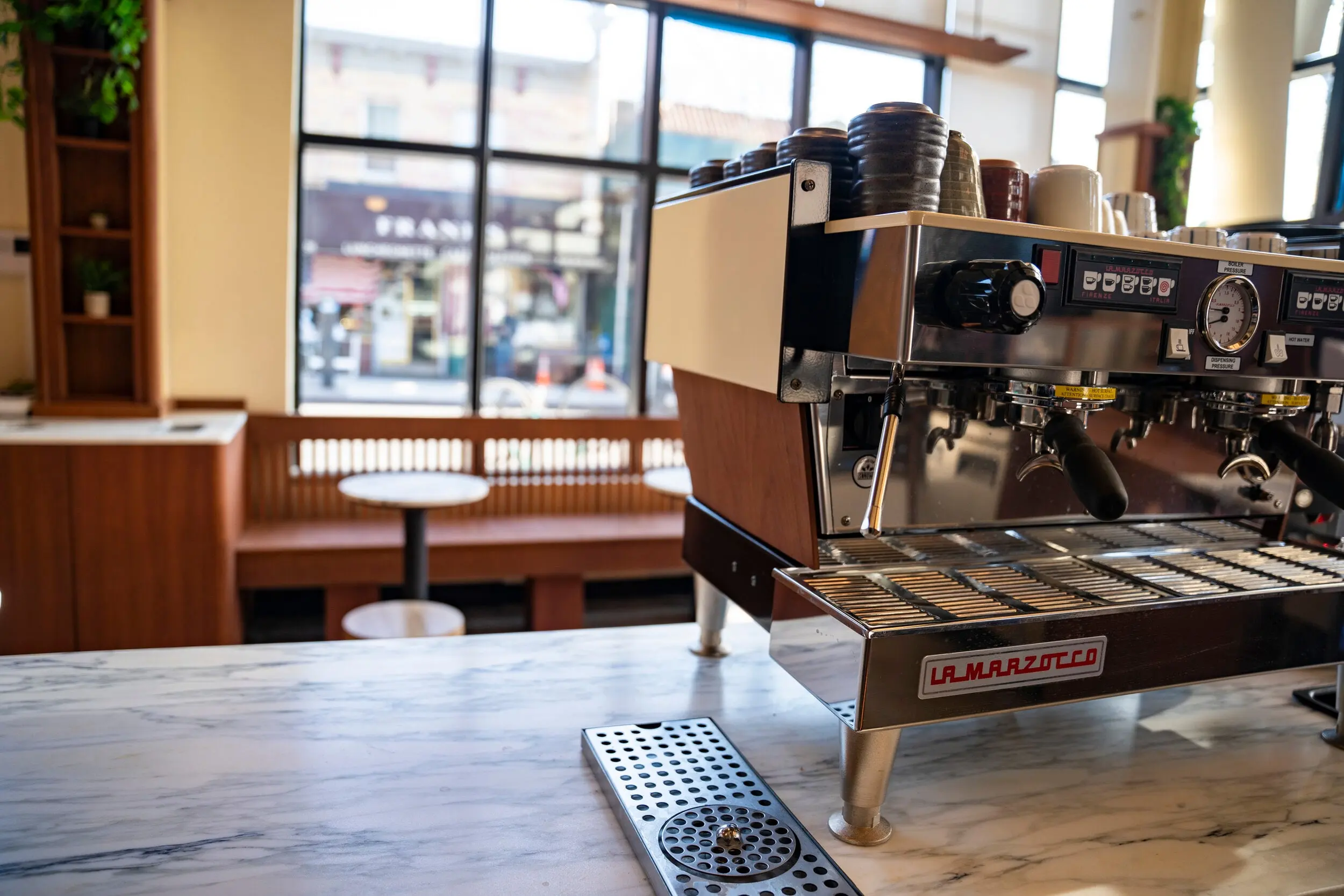 Espresso machine on the marble counter at Nili with the street beyond