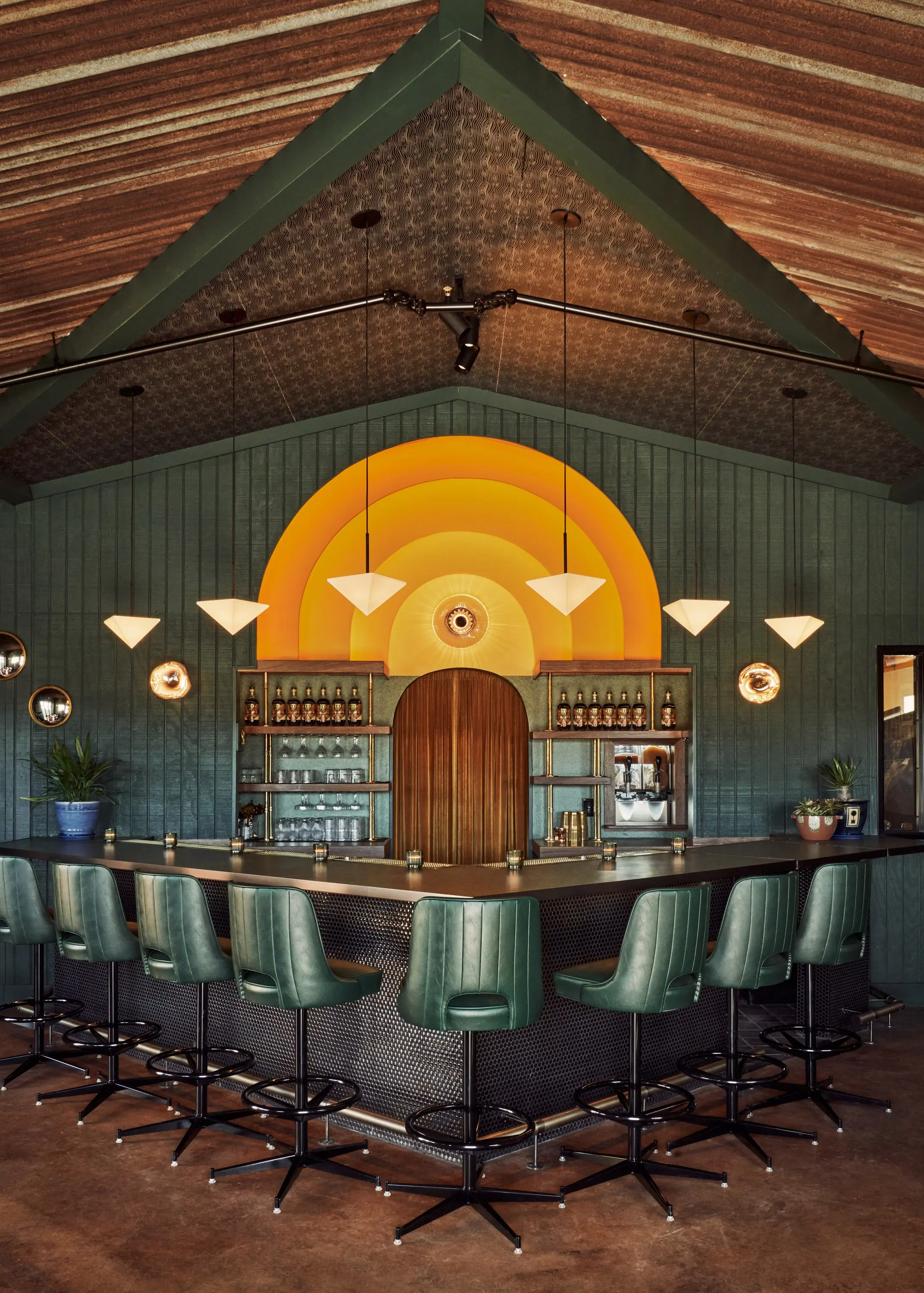 The arched back bar at Senza Maeso with concentric amber rings and a central pendant