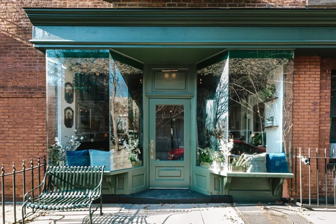 Green-painted storefront of Clover Hill on a Brooklyn brick building