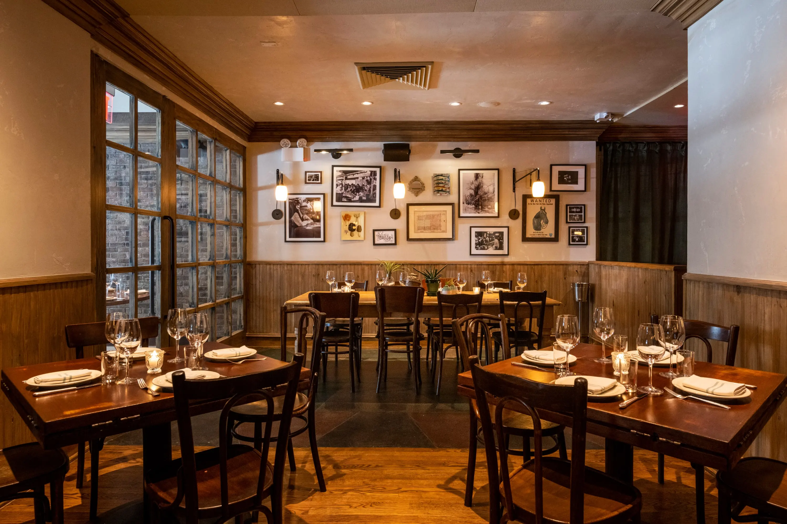 The Fountain Room at One Fifth with framed photographs, wainscot and set tables