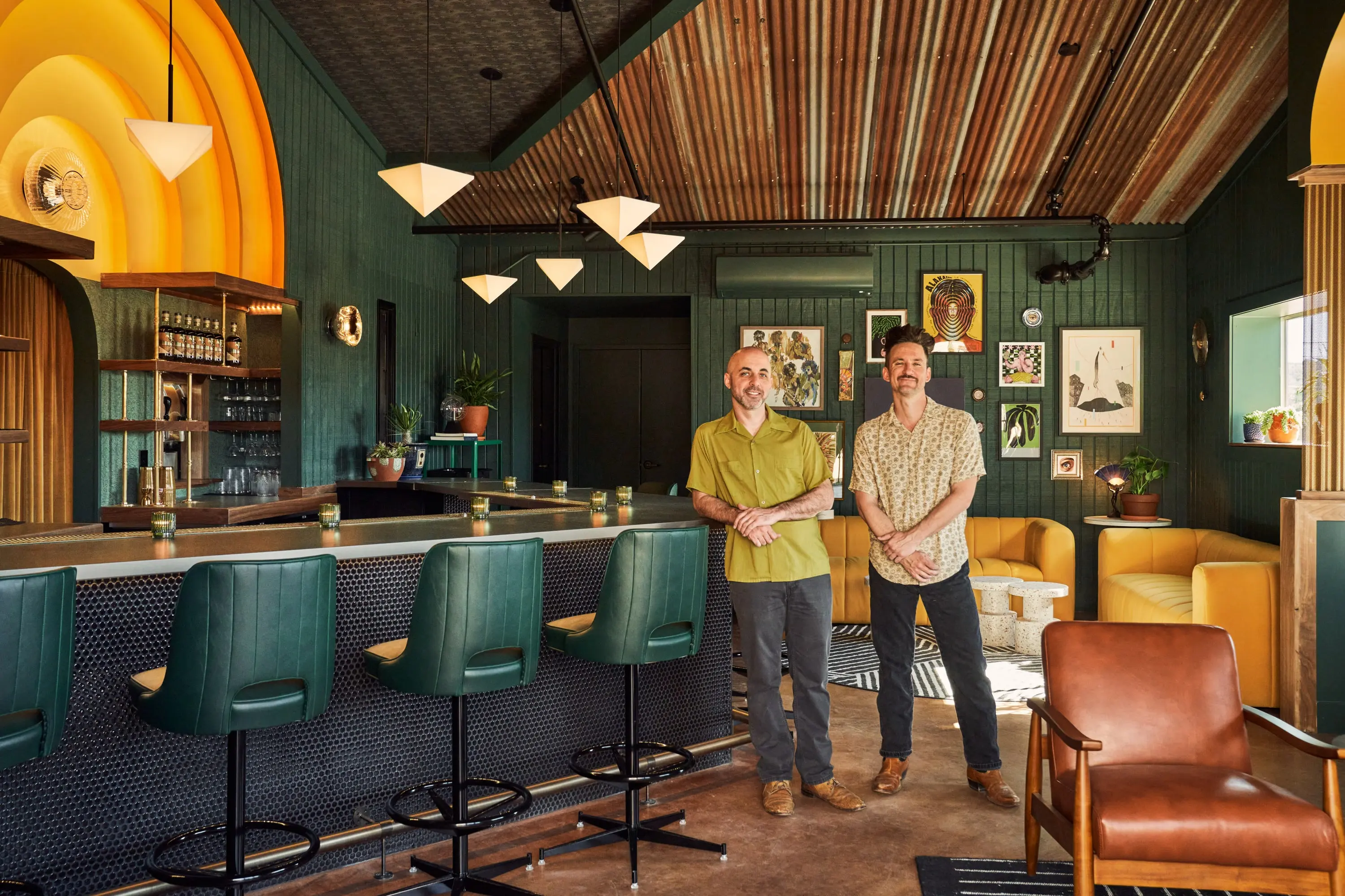 Lounge seating at Senza Maeso with leather armchairs, mustard cushions and gallery wall