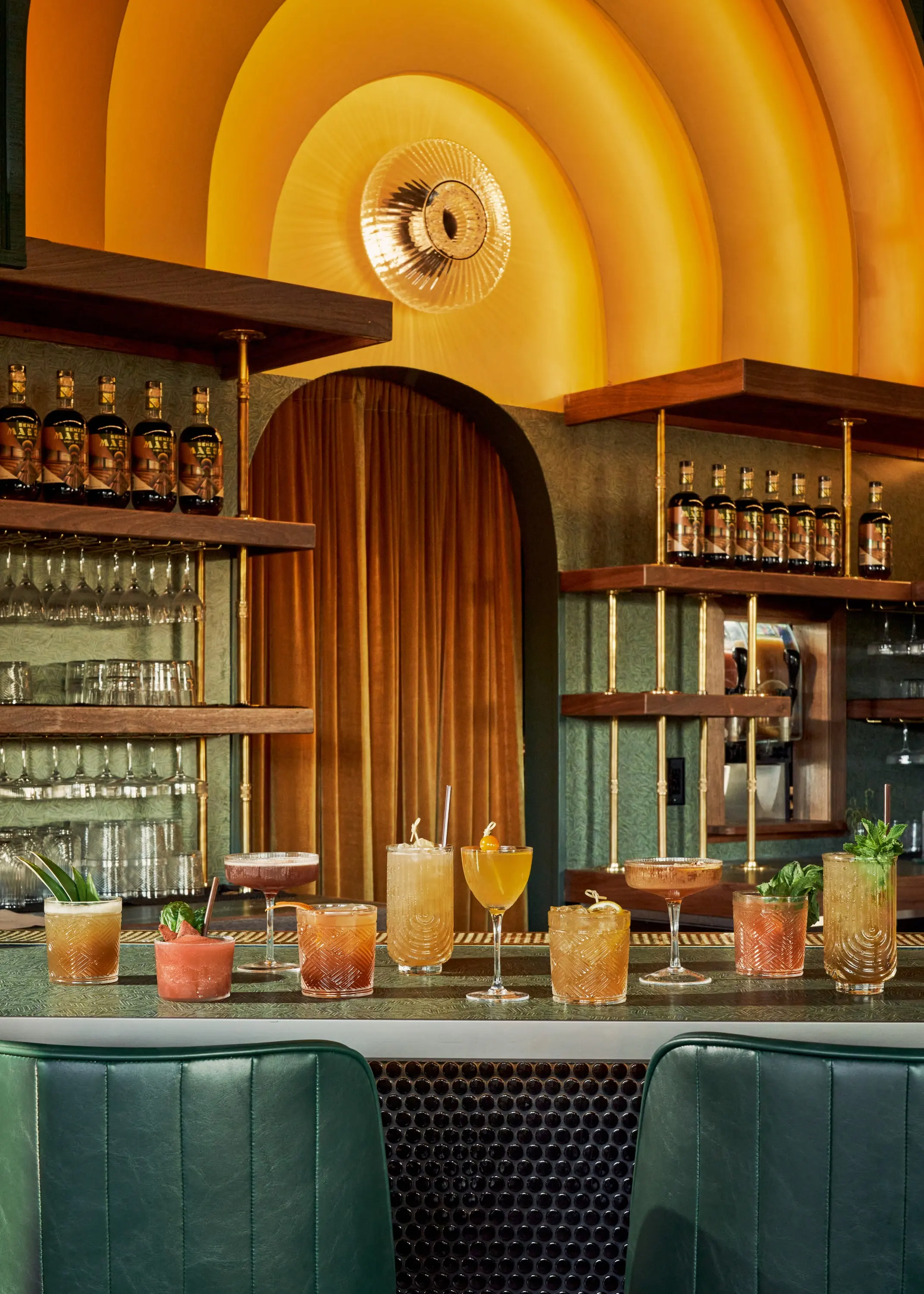 Cocktails lined up on the bar at Senza Maeso beneath the arched back bar