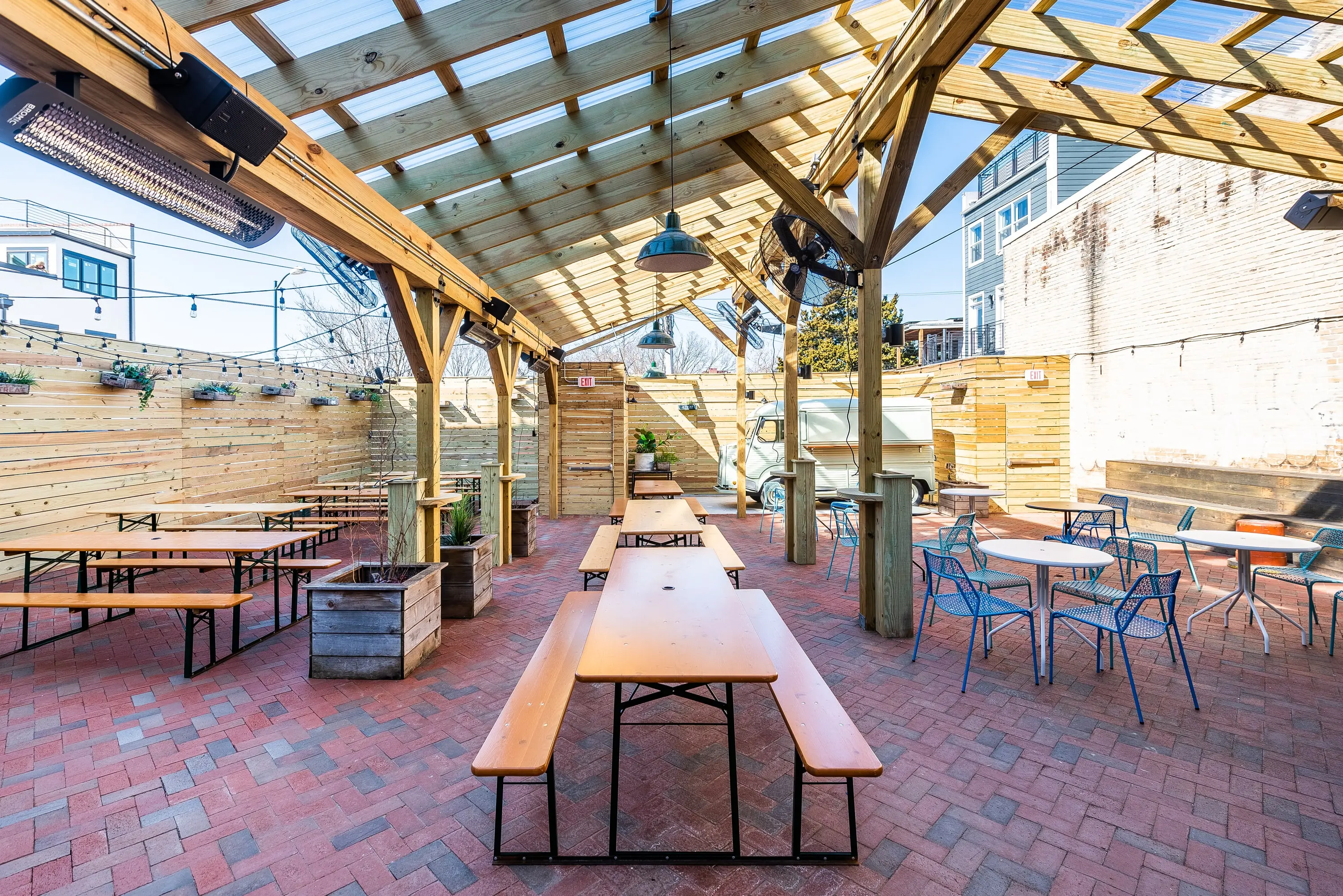Covered pergola patio at Sonny's Pizza with picnic tables and heaters