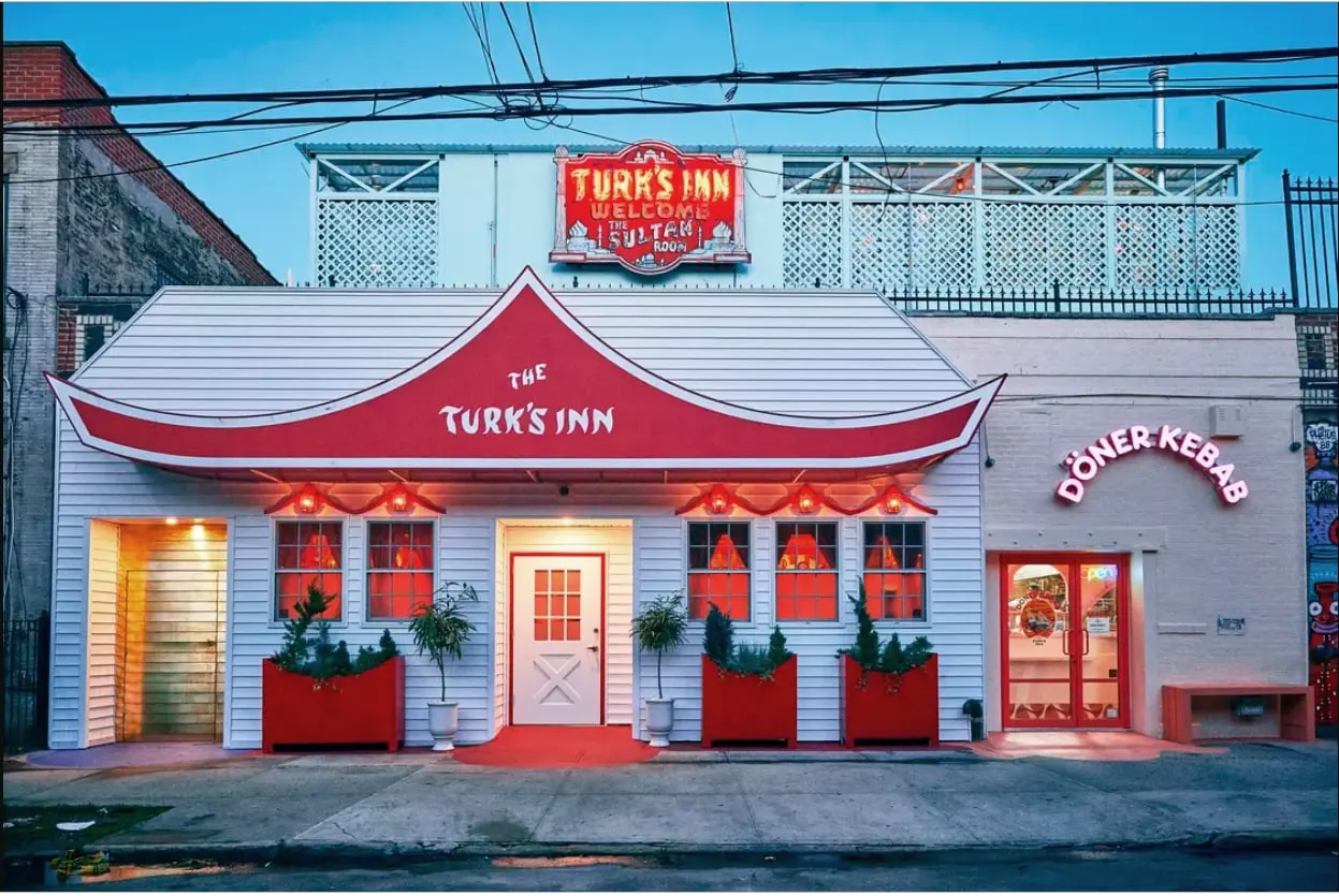 Turk's Inn exterior at dusk with its red pagoda roof and glowing sign