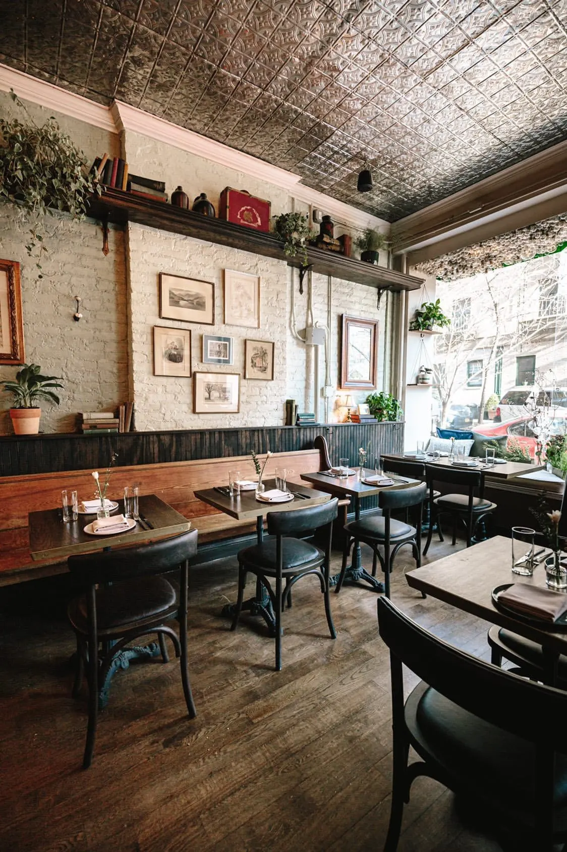 Clover Hill dining room in daylight, tables set along the banquette beneath a pressed-tin ceiling