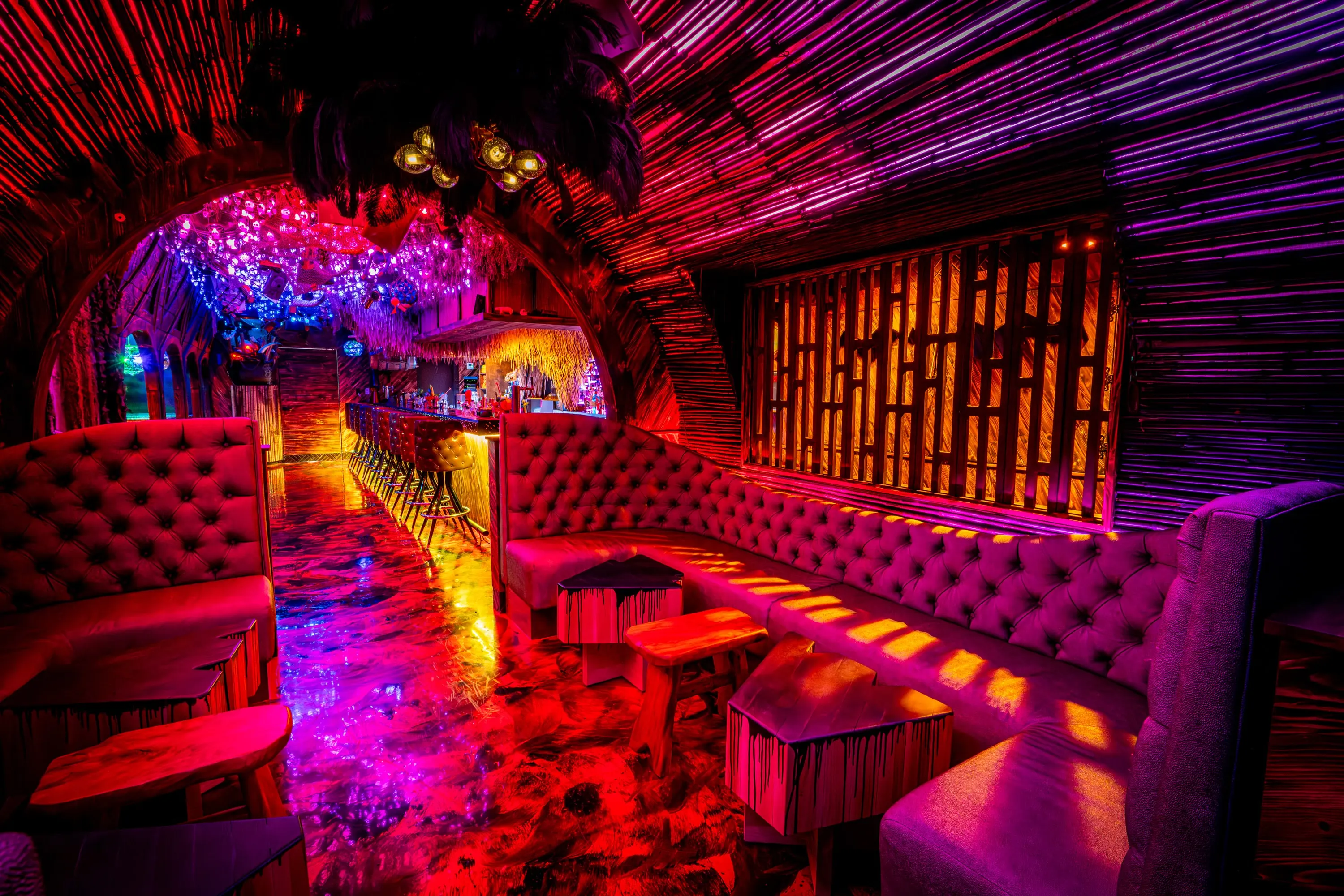 Tufted purple banquette in the lounge at Paradise Lost with a view toward the bar