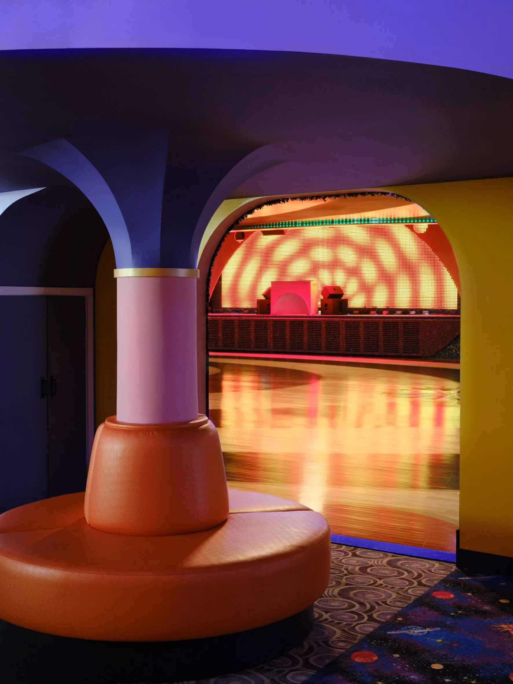 Rounded padded seat wrapping a column at Xanadu with the rink beyond