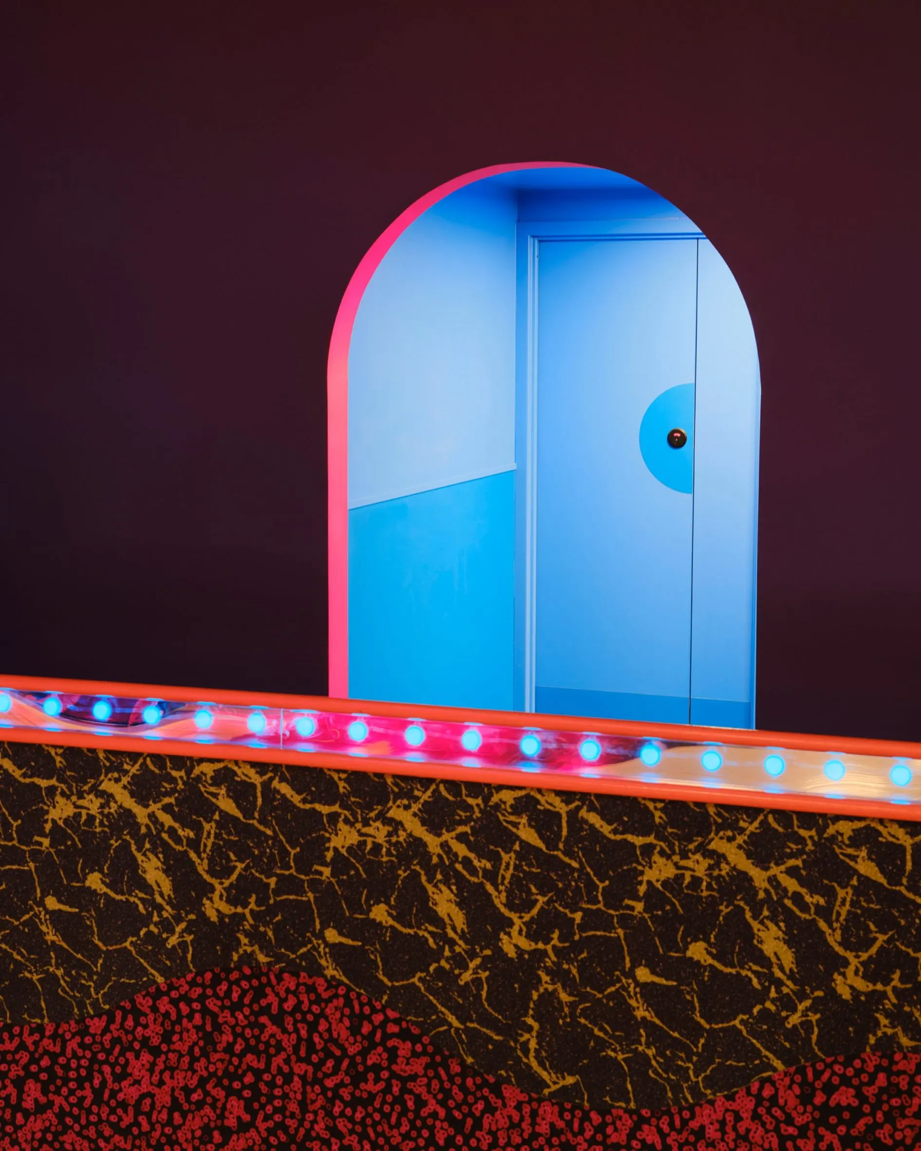 Blue arched door and terrazzo-patterned counter at Xanadu