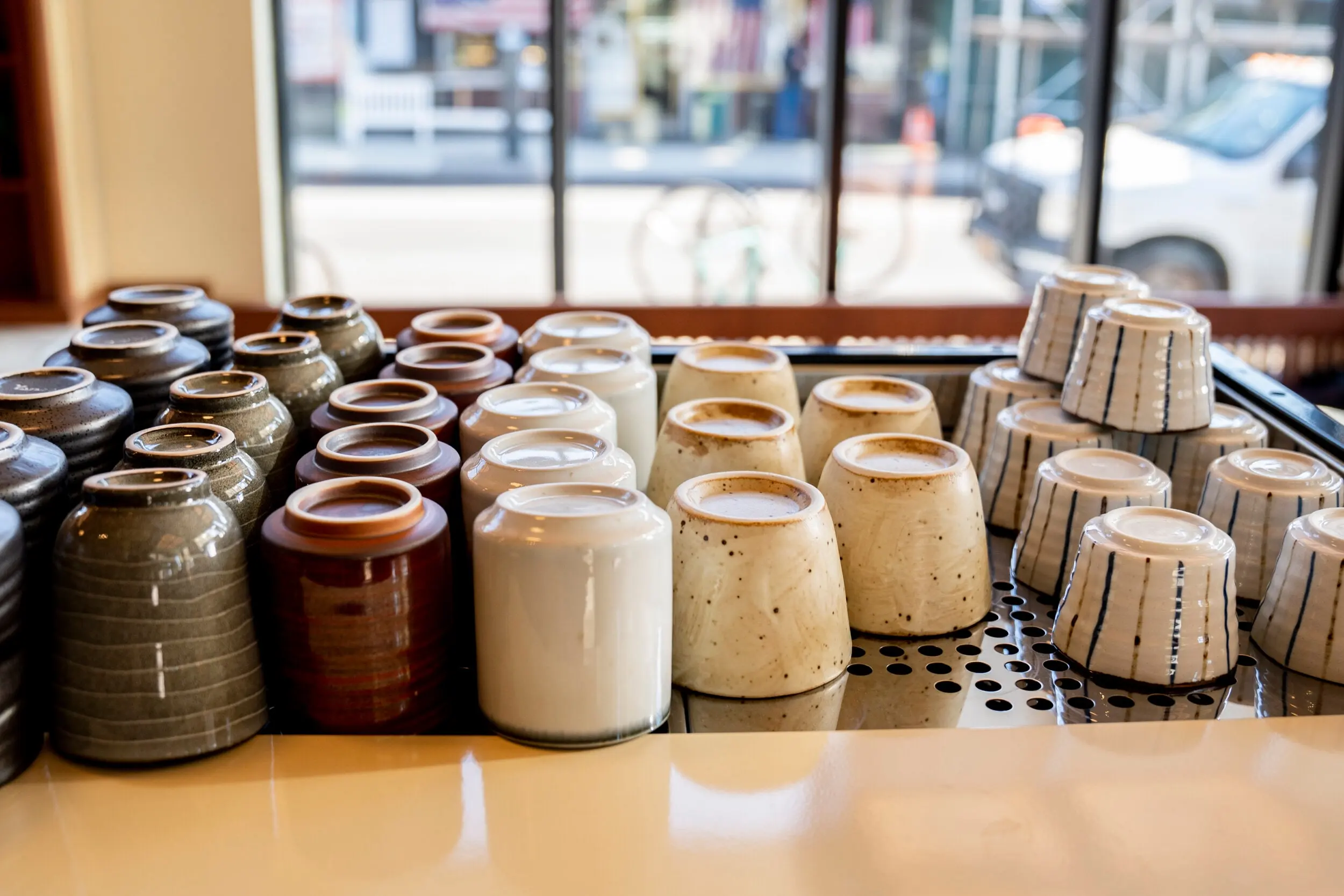 Ceramic cups lined up on the counter at Nili in morning light
