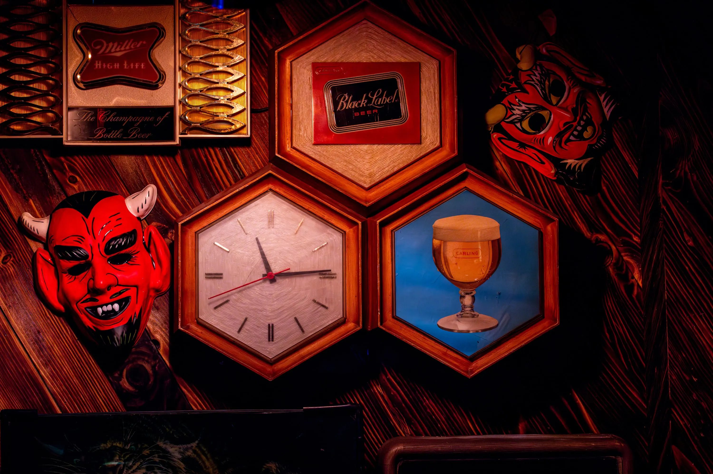 Hexagonal shadow boxes holding curated artifacts on a carved wall at Paradise Lost