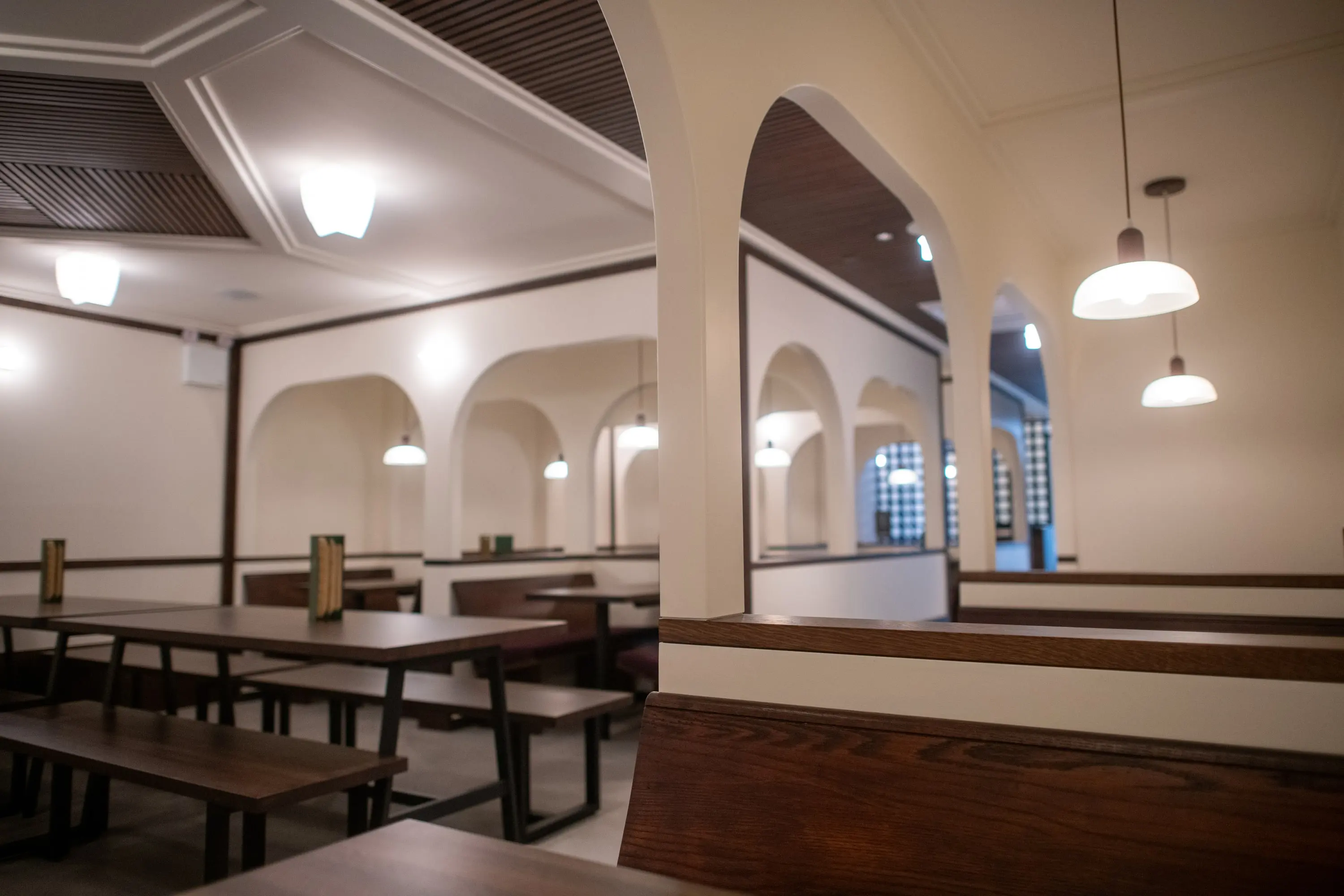 Row of arched booths beneath a coffered ceiling at Eckhart Beer Co