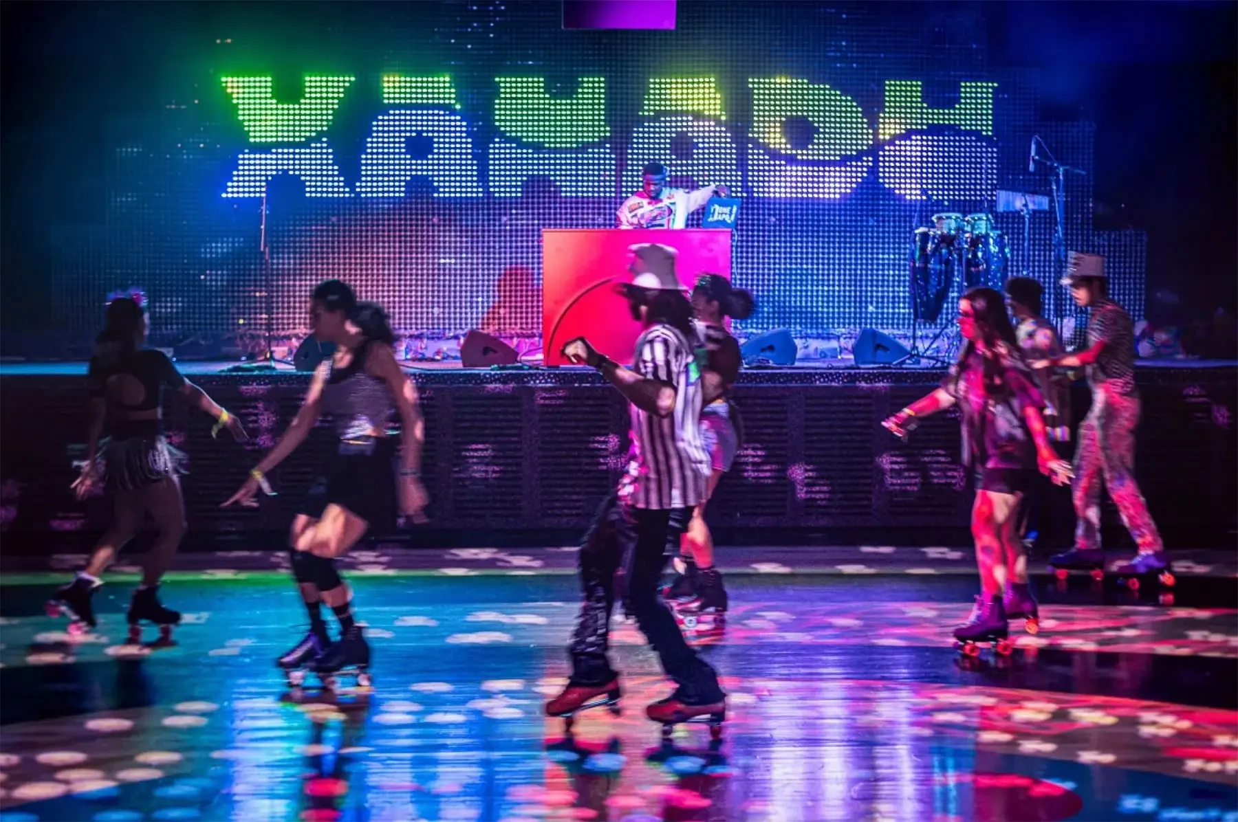 Skaters on the rink at Xanadu beneath the illuminated sign