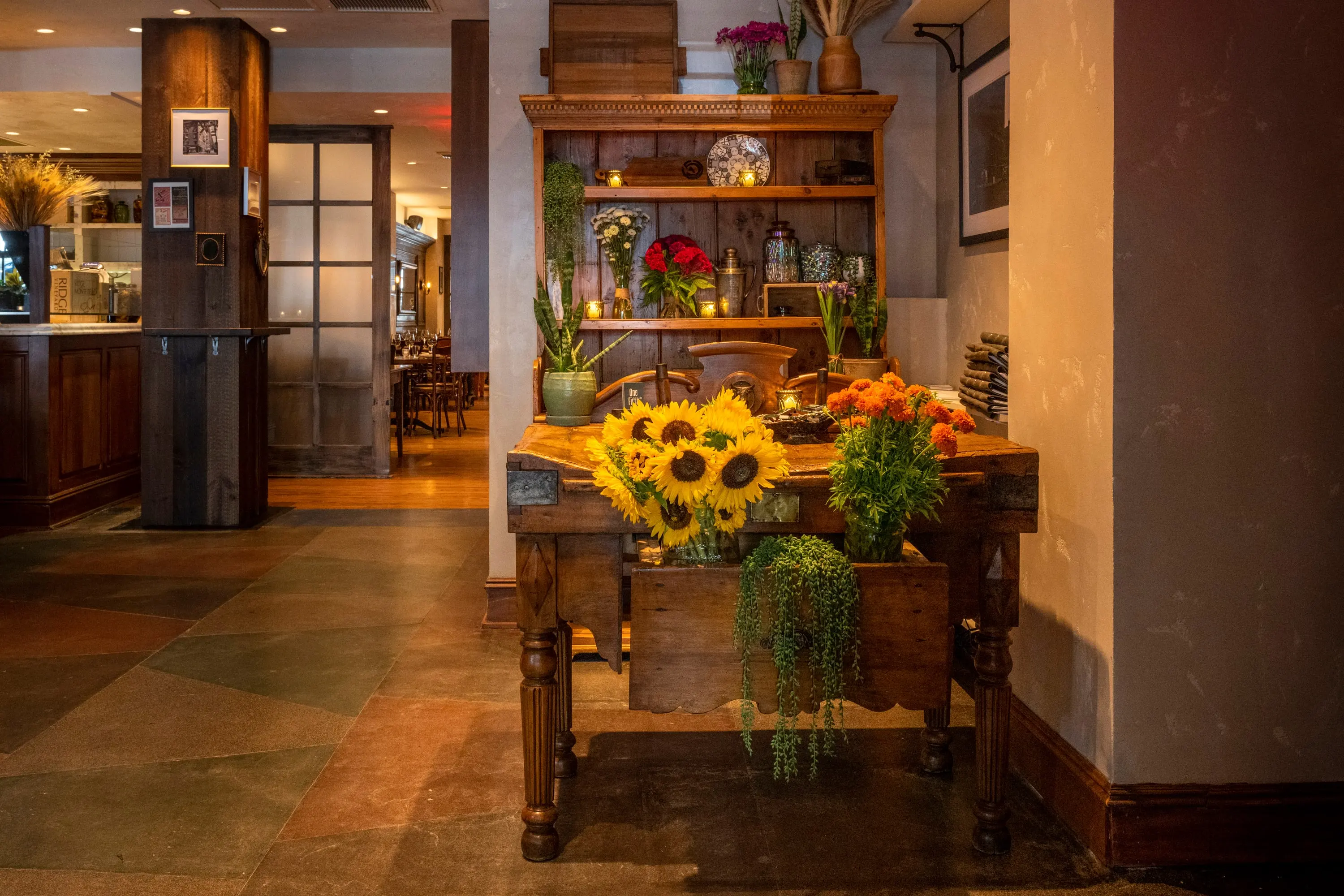 Host stand at One Fifth with sunflowers and a view into the dining room